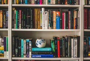 assorted-labeled book lot on white wooden shelf